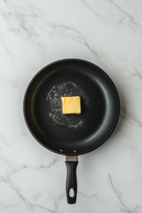 This image shows butter or oil heating in a frying pan