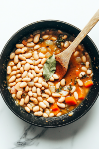 This image shows a bouillon cube being dissolved in water to create a flavorful broth for the vegetable and pinto bean soup.