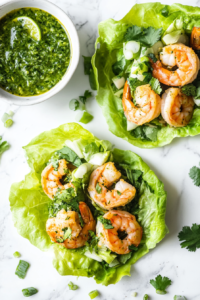 This image shows warm tortillas and crisp romaine lettuce leaves being filled with juicy cilantro lime shrimp, ready to be topped with fresh garnishes.