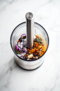 This image shows a rich blend of fresh spices, coconut, and red chilies being ground into a smooth, fragrant paste, which forms the flavorful base of Goan Fish Curry.