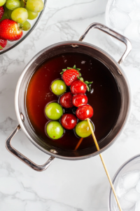 dipping-fruit-skewers-into-hot-sugar-syrup-to-create-a-glossy-candy-coating