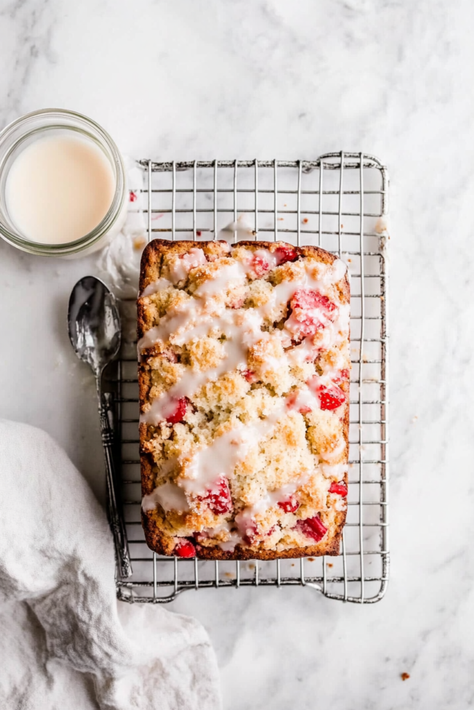 drizzling-a-sweet-glaze-over-the-cooled-strawberry-rhubarb-bread-1147502-683x1024