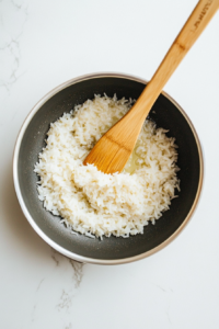 Olive oil is heating in a pan, with Bomba rice added to start the cooking process, creating a rich foundation for flavor.