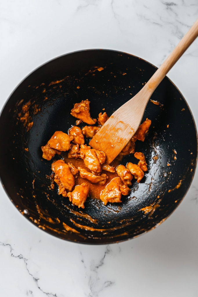 tossing-crispy-fried-chicken-in-orange-sauce-7525402-683x1024