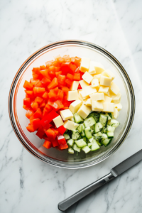 chopped-cheese-bell-peppers-and-pickles-in-glass-bowl-on-white-marble-2